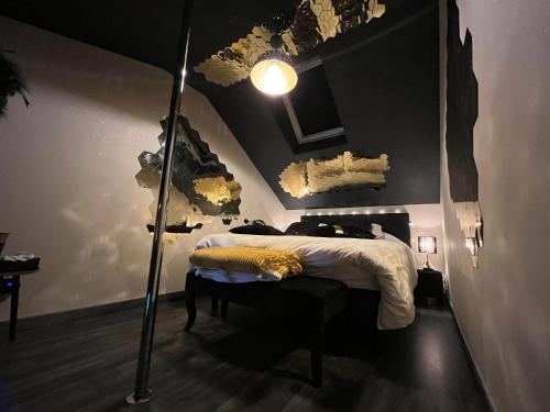 a bedroom with a bed and a floor lamp at La tentation in Berck-sur-Mer