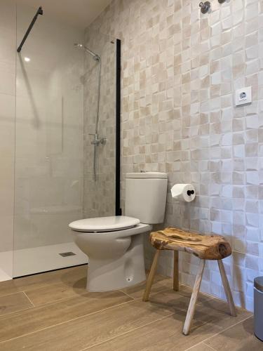 uma casa de banho com um WC, um chuveiro e um banco em Rincón de picos em Cangas de Onís