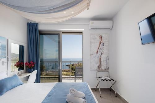 a bedroom with a bed and a view of the ocean at Contessina del mare in Panormos Rethymno