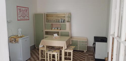 a small kitchen with a table and a refrigerator at Hortenzia Vendégház Márianosztra in Márianosztra