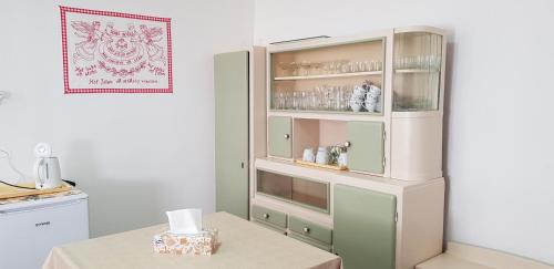 una cocina con una cabaña blanca y una mesa en Hortenzia Vendégház Márianosztra, en Márianosztra