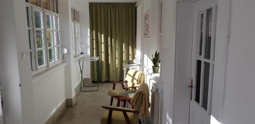 a hallway with chairs and a table in a room at Hortenzia Vendégház Márianosztra in Márianosztra
