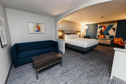 a hotel room with a bed and a couch at Holiday Inn Express and Suites Urbandale Des Moines, an IHG Hotel in Urbandale