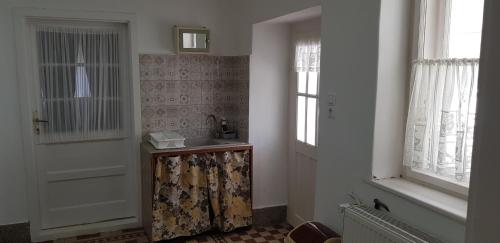 a bathroom with a door and a sink and a window at Hortenzia Vendégház Márianosztra in Márianosztra