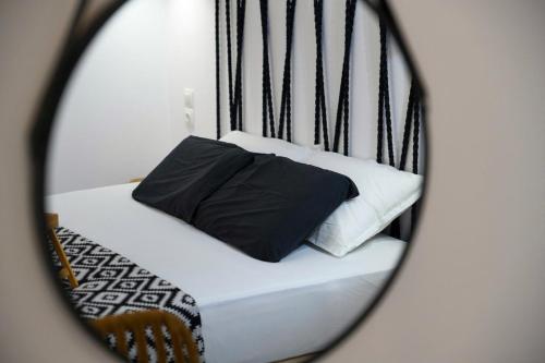 a bed with black and white pillows in a mirror at Casa De Lago in Agios Nikolaos