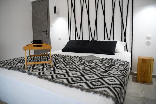 a bed with a black and white blanket and a table at Casa De Lago in Agios Nikolaos
