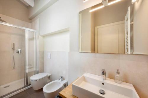 La salle de bains blanche est pourvue d'un lavabo et de toilettes. dans l'établissement LISZT HOME by KlabHouse, à Bellagio