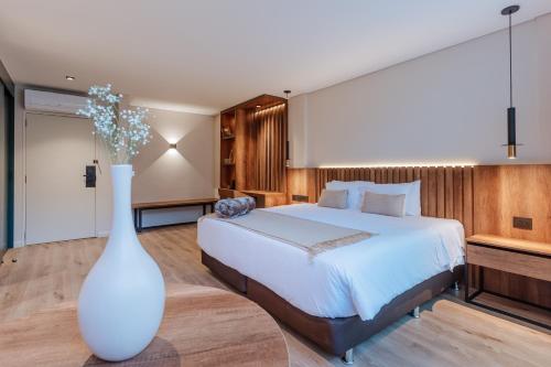 a bedroom with a bed and a large white vase at 1616 Hotel in Medellín