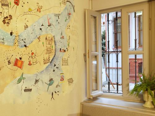 a mural on a wall in a room with a window at Tilas - Rooms in 19th Century Wooden Townhouse,Kadikoy in Istanbul