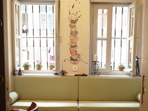 a living room with two windows and a couch at Tilas - Rooms in 19th Century Wooden Townhouse,Kadikoy in Istanbul
