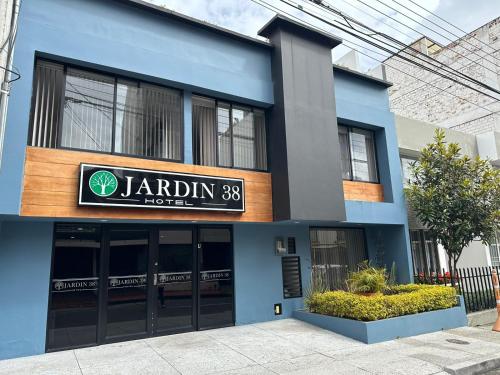 un bâtiment bleu avec un panneau indiquant un restaurant dans l'établissement HOTEL JARDIN 38, à Pasto
