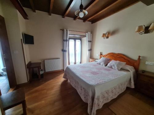 a bedroom with a bed with a white bedspread at Hotel La Balsa in Cangas de Onís