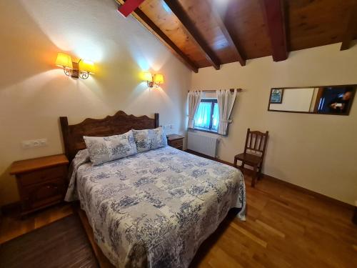 a bedroom with a bed and a chair in it at Hotel La Balsa in Cangas de Onís