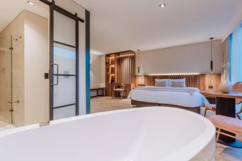 a hotel room with a bed and a bathroom at 1616 Hotel in Medellín