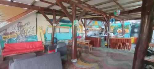 プエルト・ヒメネスにあるOSA SURF HOSTALの赤いソファと壁画のあるリビングルーム