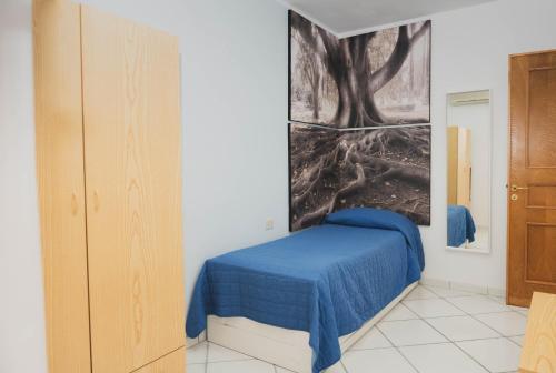 Un dormitorio con una cama azul con una foto en la pared en Casa Ravello, en Ravello