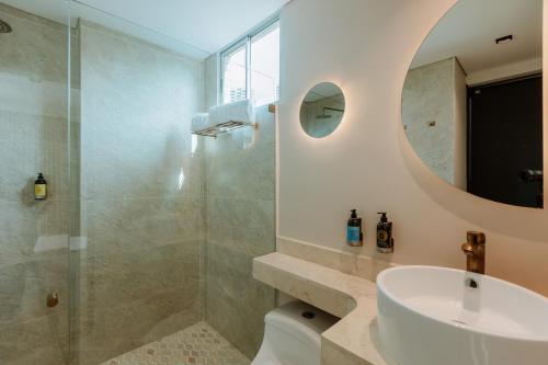a bathroom with a shower and a sink and a mirror at 1616 Hotel in Medellín