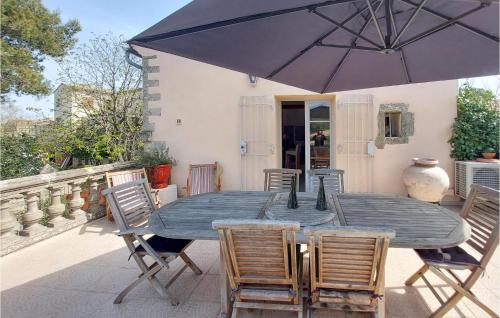 une table avec des chaises et un parasol sur une terrasse dans l'établissement Lovely Home In Murviel Les Montpellie, à Murviel-lès-Montpellier