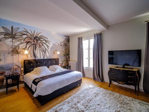 een slaapkamer met een groot bed en een televisie bij Aux Marquises in Saumur