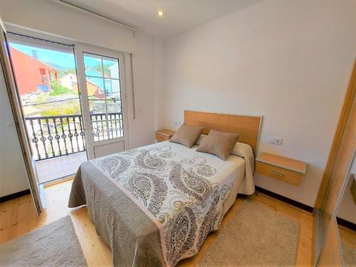 a bedroom with a bed and a large window at INcostadamorte Corral da Laxe in Dumbría