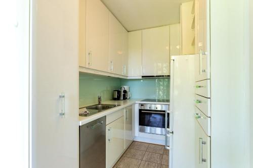 a kitchen with white cabinets and a white refrigerator at Ferienwohnung Renate in der Villa Seeblick in Bad Saarow