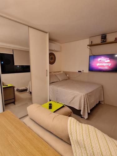 a room with a bed and a tv on the wall at The Park- no coração de POA in Porto Alegre