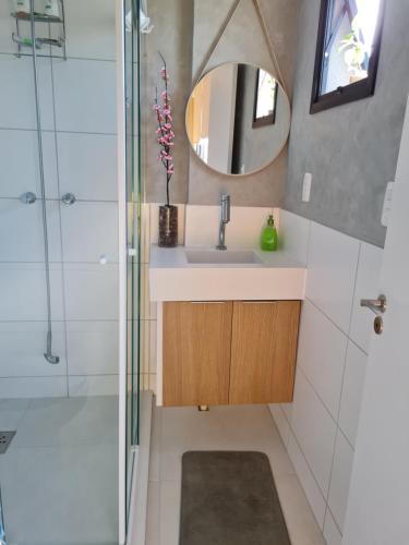 a bathroom with a sink and a shower and a mirror at The Park- no coração de POA in Porto Alegre