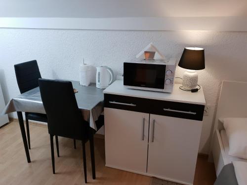Habitación con escritorio, microondas y mesa con sillas. en Apartments Nena, en Smoljanac