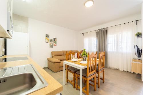 une cuisine et un salon avec une table et un canapé dans l'établissement Apartamento Jibazahora P6 - Primera Planta, à Zahora