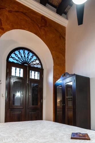 a bedroom with a wooden door and a window at Casa Sol Bed and Breakfast in San Juan
