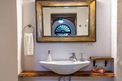 a bathroom with a white sink and a mirror at Casa Sol Bed and Breakfast in San Juan