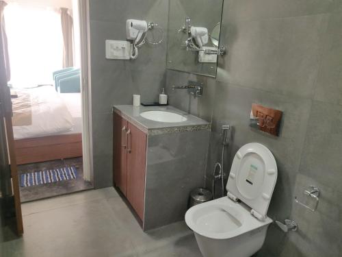 a small bathroom with a toilet and a sink at The Periwinkle Homestay Bhimtal in Bhīm Tāl