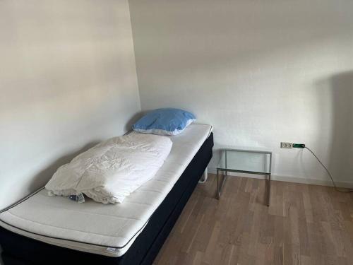 a small bed in a room with a white wall at Dejligt stort hus med spa in Ålbæk