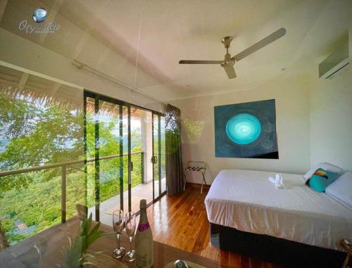 a bedroom with a bed and a large window at Organica Yoga Shelter in Paquera