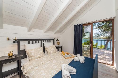 1 dormitorio con cama y ventana grande en Little Sea House, en Pašman