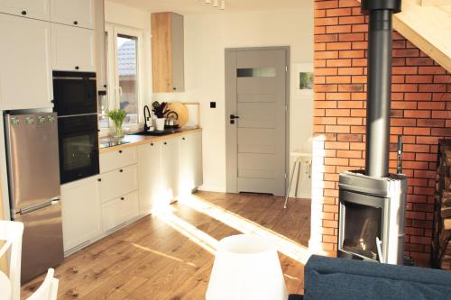 a kitchen with a brick wall and a stove at Mazury domek nad jeziorem z jacuzzi in Szczytno