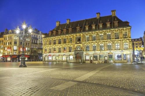 ein großes Gebäude mitten in einer Straße nachts in der Unterkunft Maisonette Tran in Lille
