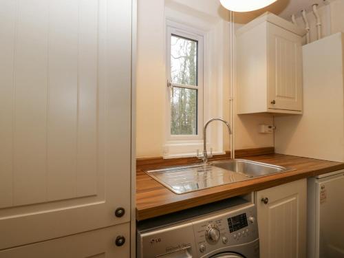 a kitchen with a sink and a dishwasher at Heathfield in Taunton