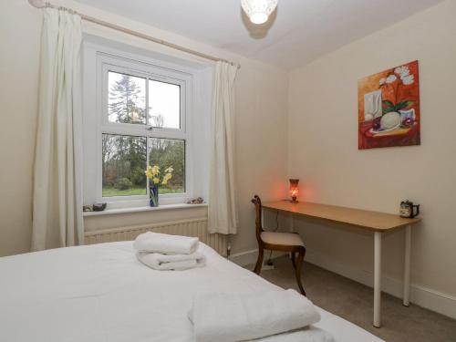 a bedroom with a bed and a desk and a window at Heathfield in Taunton