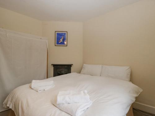 a white bed with two towels on top of it at Heathfield in Taunton