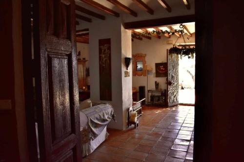 sala de estar con sofá y puerta abierta en Torre de Arriba Casa Rural, en Benimantell