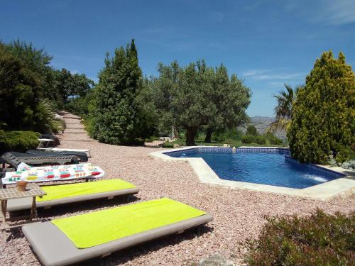 una piscina con tumbonas junto a ella en Torre de Arriba Casa Rural, en Benimantell