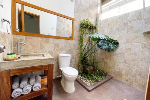 a bathroom with a toilet and a sink and a mirror at Hotel Ayenda Palmas del Río in Mompós
