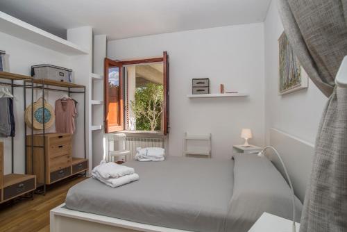 Un dormitorio blanco con una cama y una ventana. en Villa Costanza, en Mondello