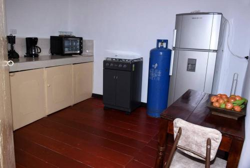 eine Küche mit einem Tisch, einem Kühlschrank und einem Tisch sidx sidx sidx in der Unterkunft Casa típica Salamineña in Salamina
