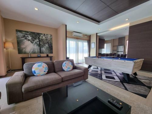 a living room with a couch and a pool table at Midas Pool Villa in Jomtien Beach
