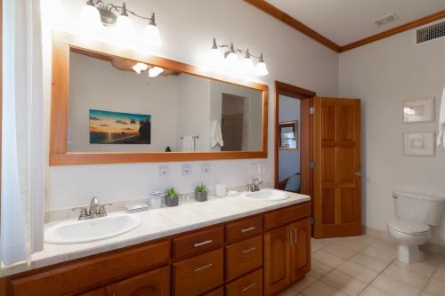 a bathroom with two sinks and a large mirror at Tara Del Sol Resort in San Pedro