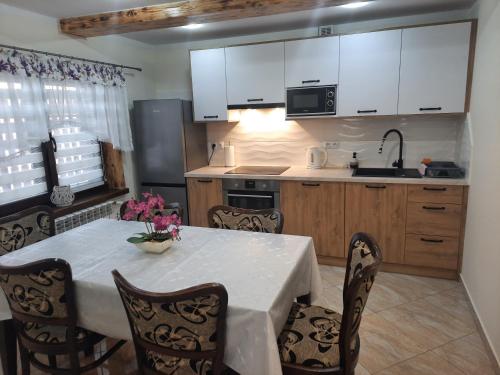 a kitchen with a table and chairs and white cabinets at ChatkaDuraje in Jaworzynka