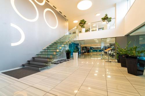 a lobby of a building with stairs and plants at Hotel Ali Baba in Humenné