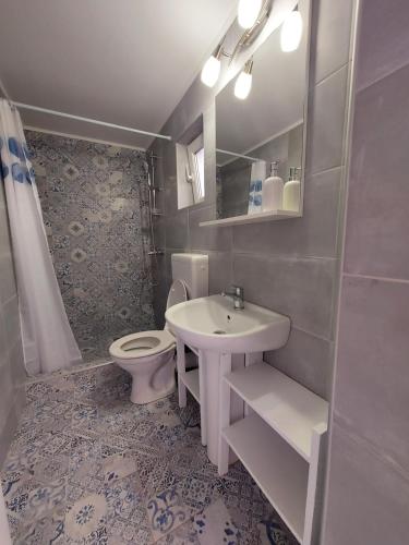 a bathroom with a sink and a toilet at Casa EMMA in Jurilovca